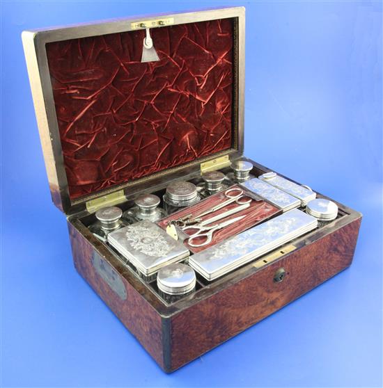 A Victorian brass mounted walnut travelling toilet box containing eleven silver mounted jars, 12in.